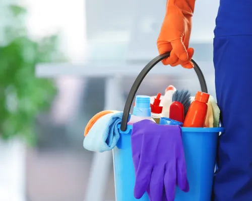 person holding bucket with cleaning products